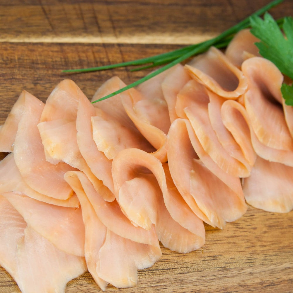 Buckellachsfilet in Scheiben kaltgeräuchert – gefächert auf Holzbrett