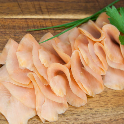 Buckellachsfilet in Scheiben kaltgeräuchert – gefächert auf Holzbrett