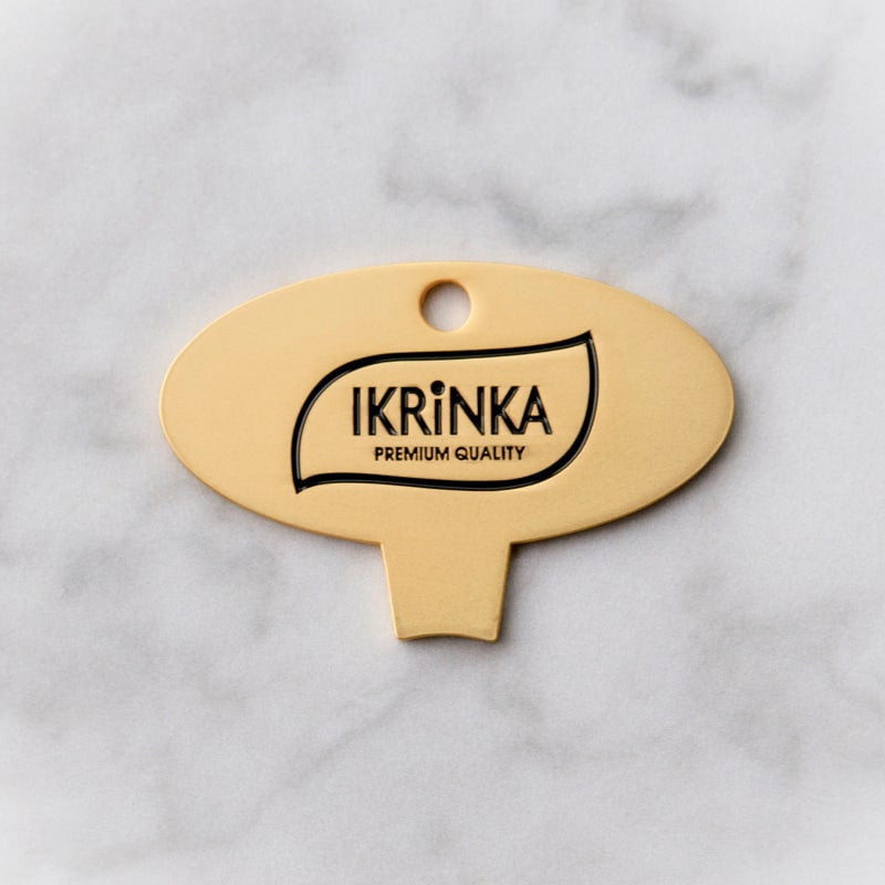 Goldener Kaviardosenöffner – IKRiNKA Öffner flach auf Marmor
