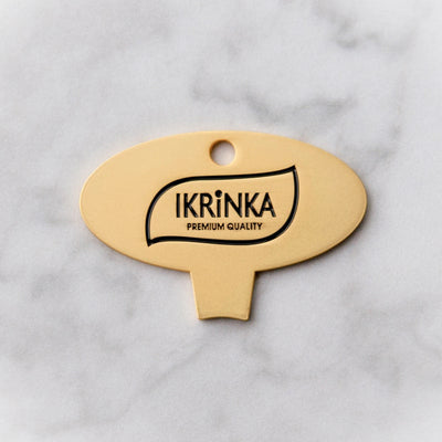 Goldener Kaviardosenöffner – IKRiNKA Öffner flach auf Marmor