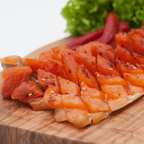 Lachsforellenfilet gedörrt pikant – Filet auf Holzbrett mit Salat